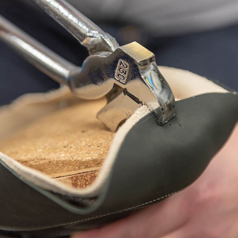 Darstellung eines Handwerkers bei der Herstellung eines Orthopädischen Maßschuhs