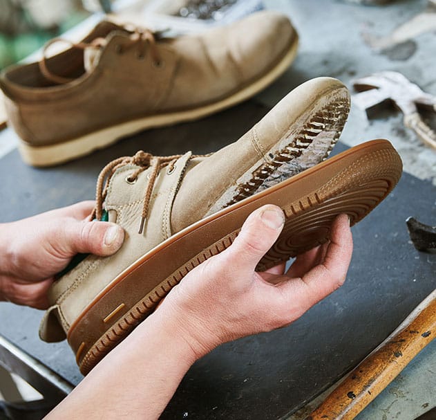 Darstellung eines Handwerkers bei der Schuhreparatur